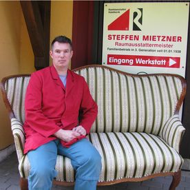 Steffen Mietzner Raumausstattermeister Ein Mann sitzt auf einer gepolsterten Bank
